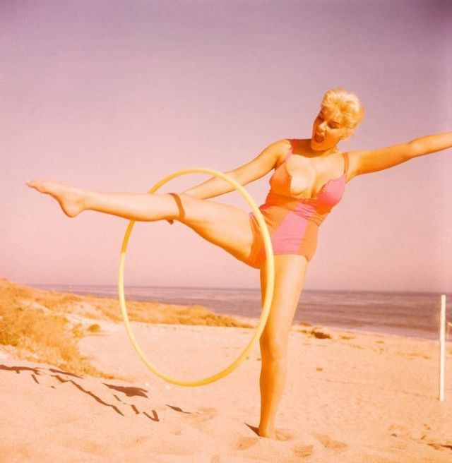 June Wilkinson playing Hula Hoop on the beach, 1960s