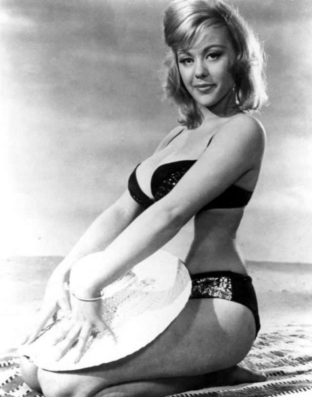 Margaret Nolan posing on the beach