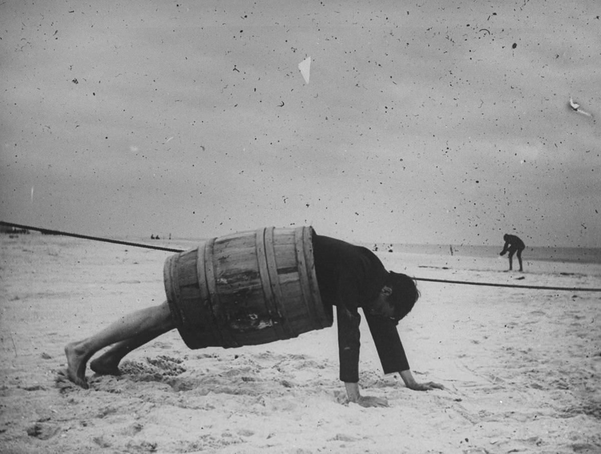 A man in a barrel does a push up at the beach.Sept. 8, 1897