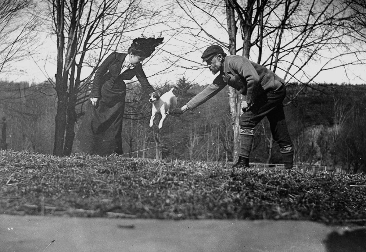 Dr. Ernest Palmer and wife join hands to make a bar so that their dog can jump over it.April 15, 1900