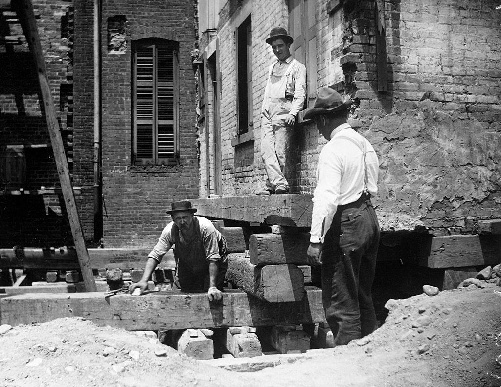 A foreman and two workers preparing a house at 314 Livingston St. for moving, New York, 1889