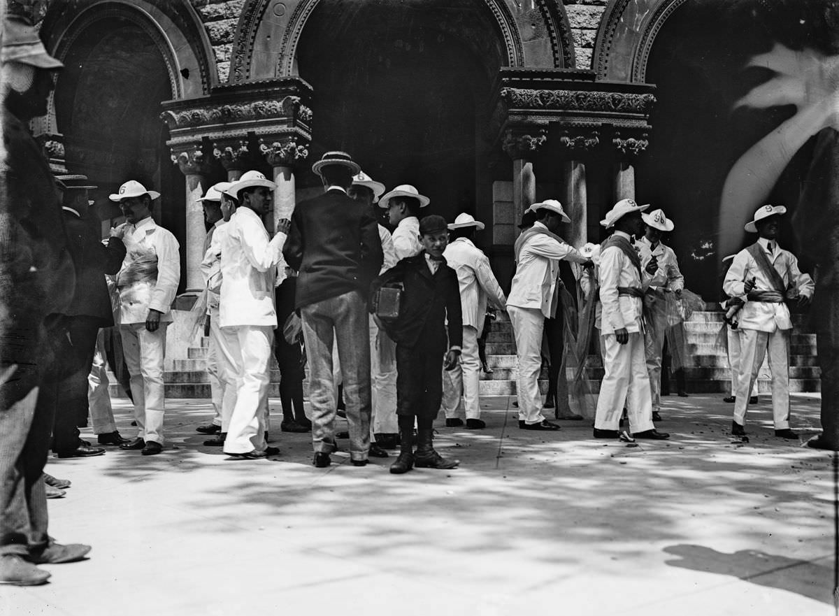 A newsboy and soldiers in a plaza, Havana, 1900