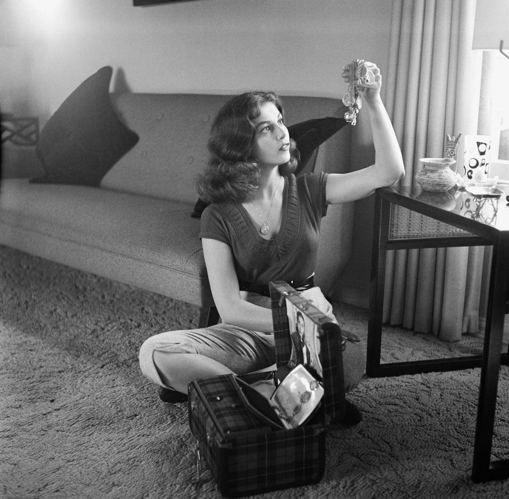 Pier Angeli examines an item of jewellery, USA, circa 1955