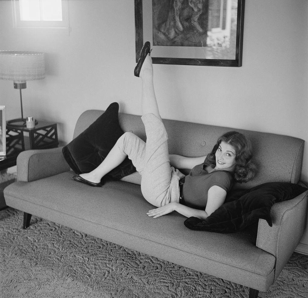 Pier Angeli relaxing on the sofa, 1955