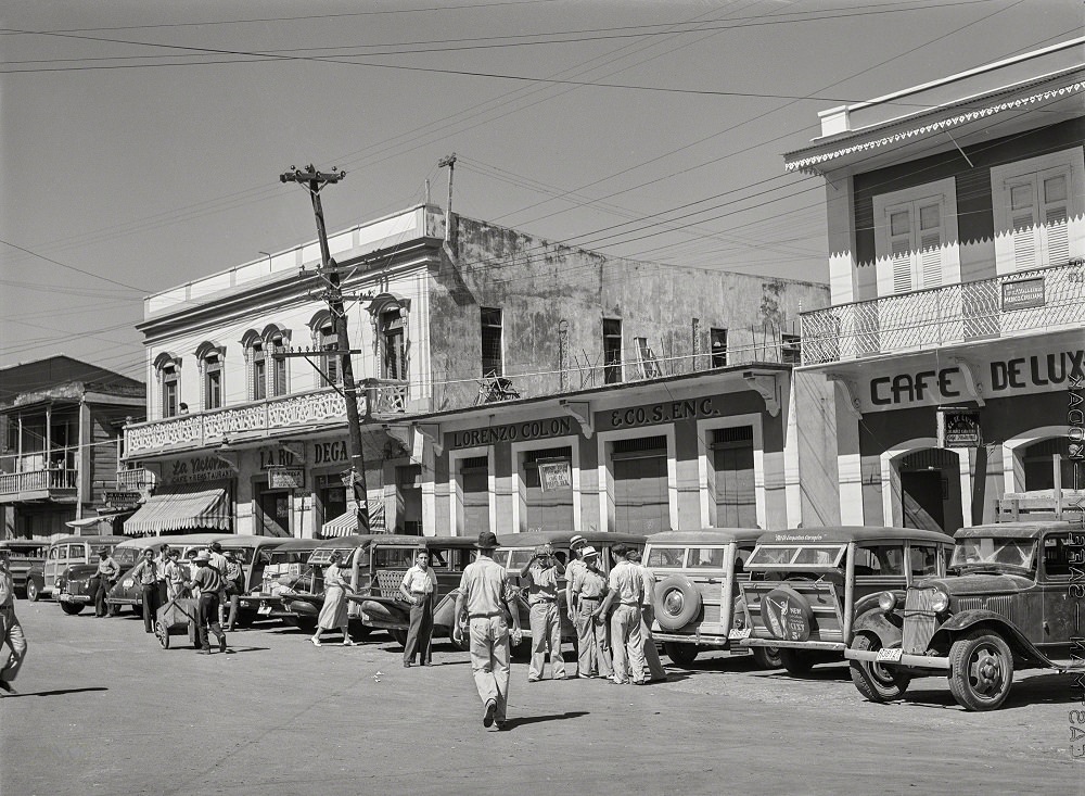 A row of station wagons or 'publicos' waiting for loads and passengers, Arecibo, Puerto Rico, January 1942