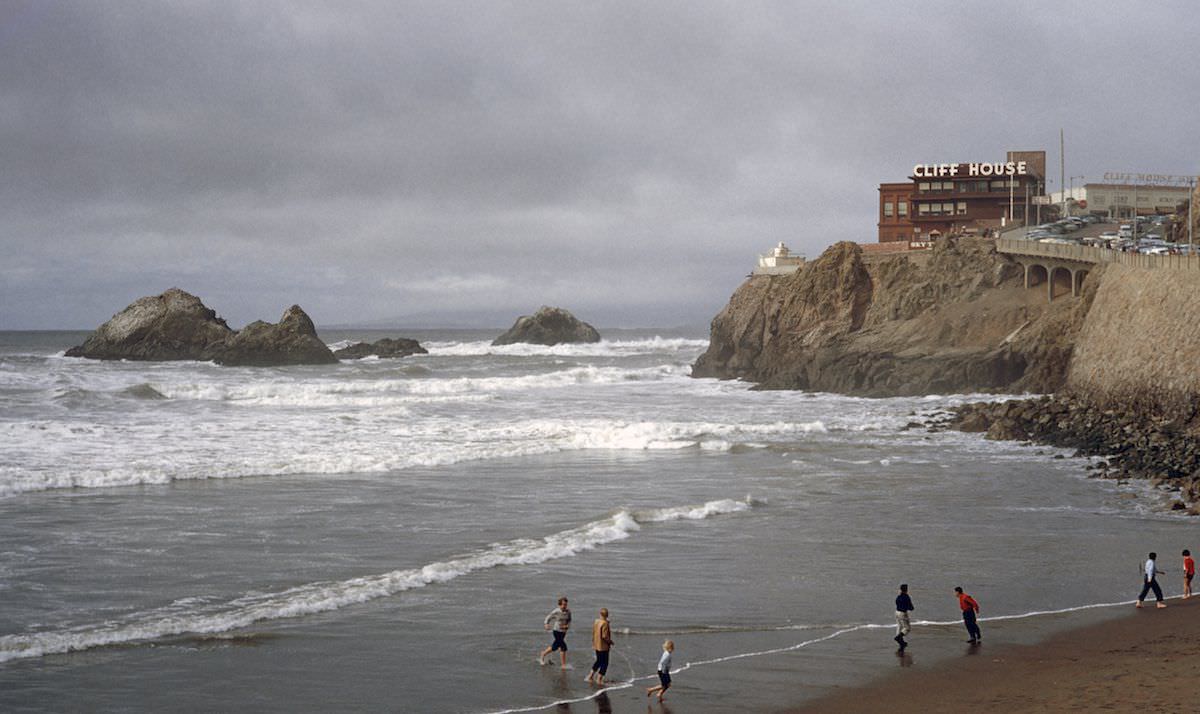 People play on a beach by Seal Rocks and the Cliff House, in San Francisco, 1956