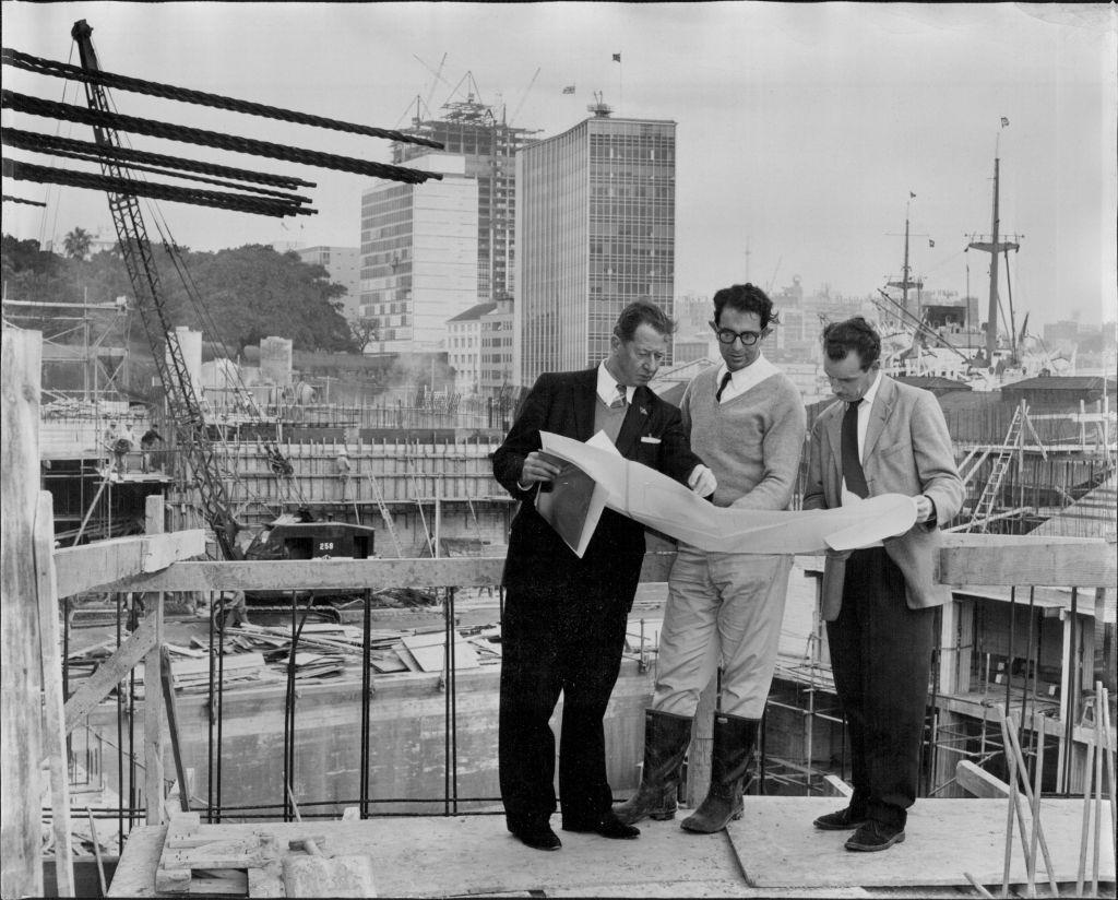 Left to right: R. J. Thomson, secretary of the Sydney Opera House Executive Committee - Mr. A. Levy, resident engineer - and Mr. O. Skipper-Nielsen, President architect with the plan of the major hall stage which is shown behind them, 1961