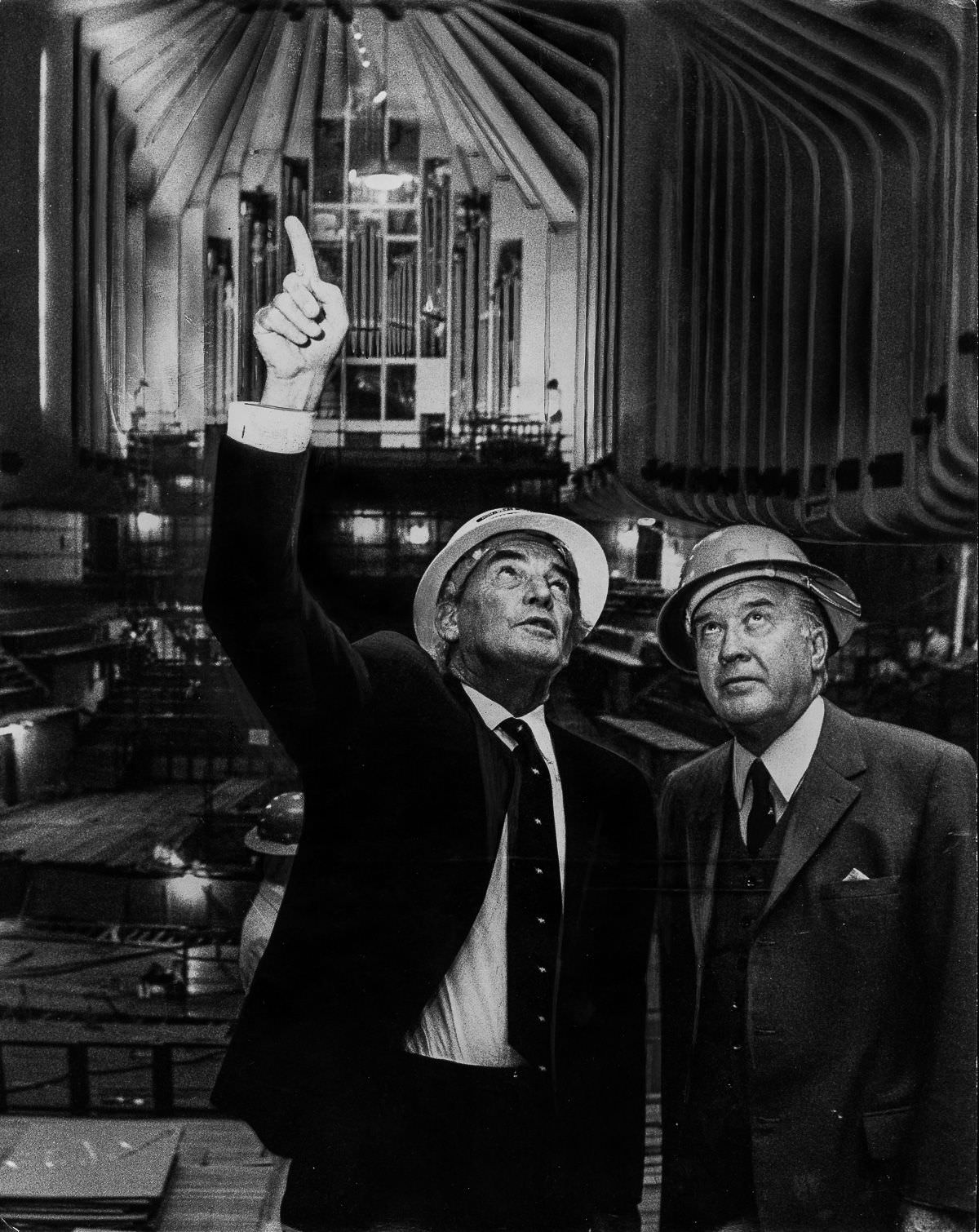 Davis Hughes közbeszerzési miniszter és Robert Askin miniszterelnök az építkezés során a Sydney Operaház koncerttermében túrázik.  Hughes öt évvel korábban, 1972. február 4-én kényszerítette Utzon lemondását.