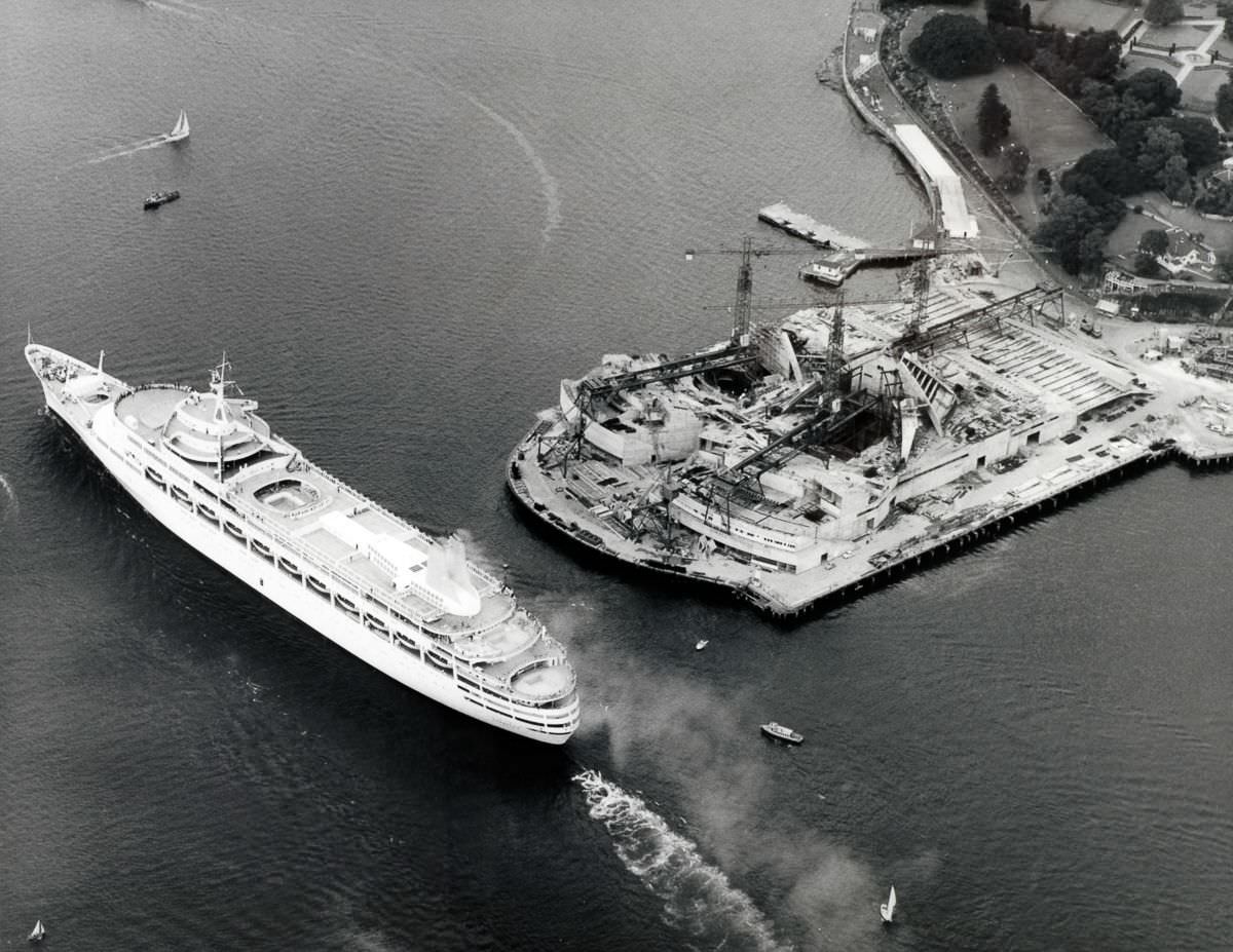 The ocean liner "Canberra" passes the construction work on the Sydney Opera House, 1961.