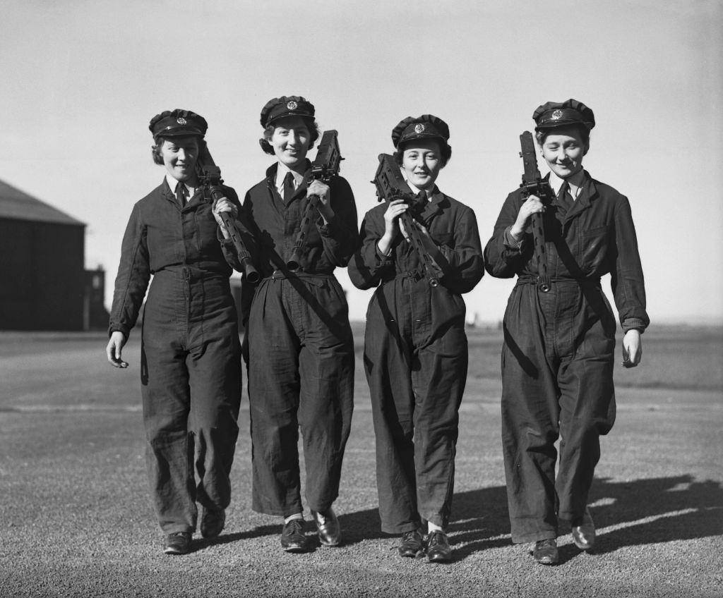 Members of the Women's Auxiliary Air Force (WAAF) carrying aircraft machine guns