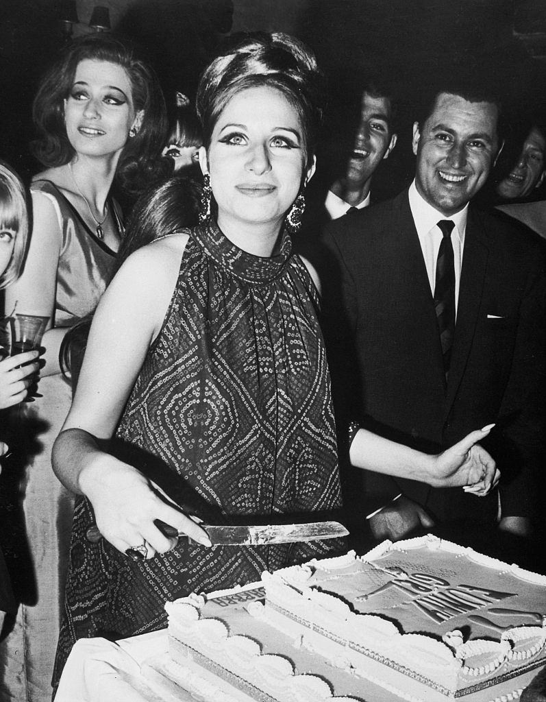 Barbra Streisand cuts the cake a farewell party for her given by the cast of "Funny Girl" in London, 1966