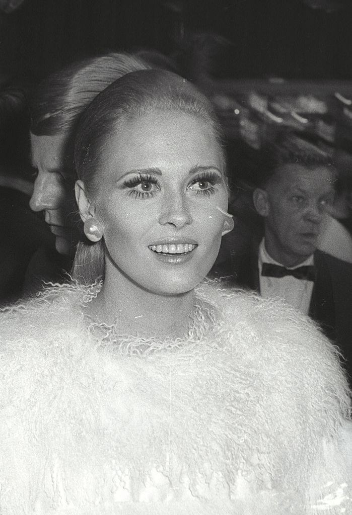 Faye Dunaway seated at 'The Factory' nightclub, wearing a pants suit, 1967