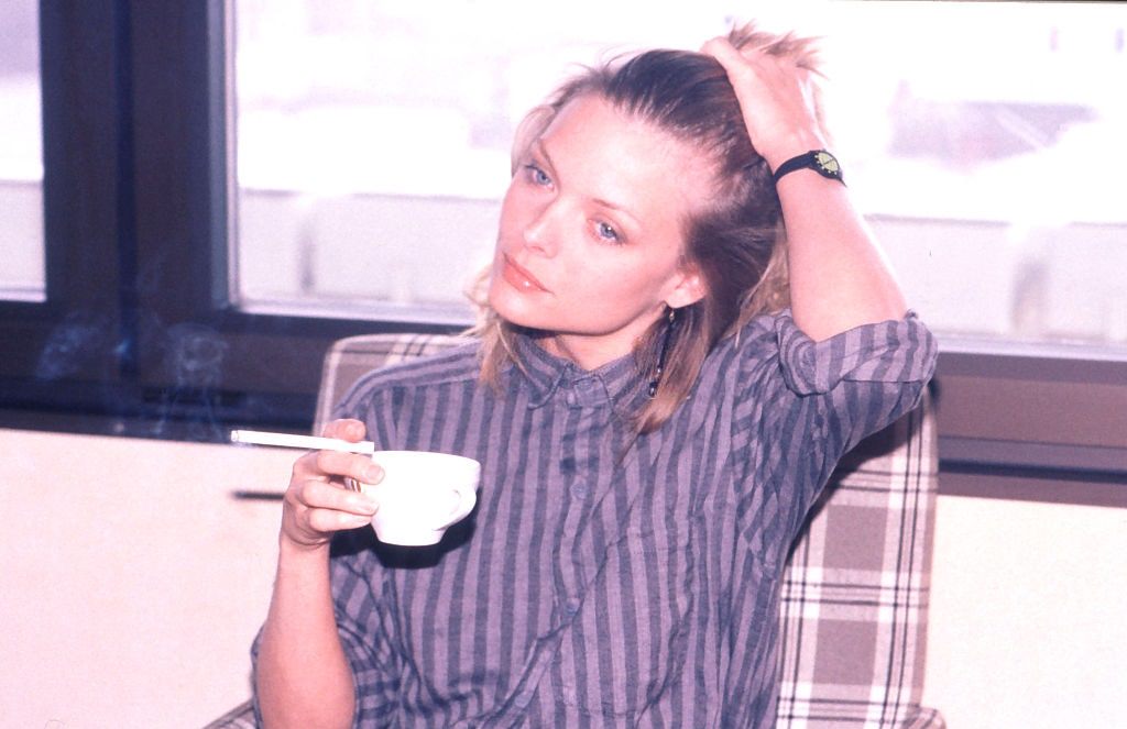 Michelle Pfeiffer taking a cigarette break during the filming, 1985