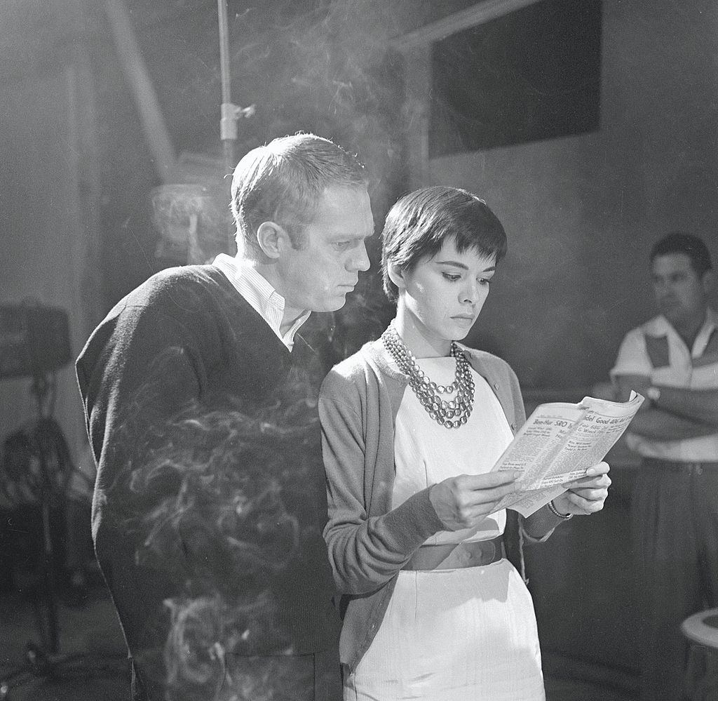 Neile Adams with her hsuband Steve McQueen reading a newspaper during the filming of an episode of 'Man from the South,' December 23, 1959