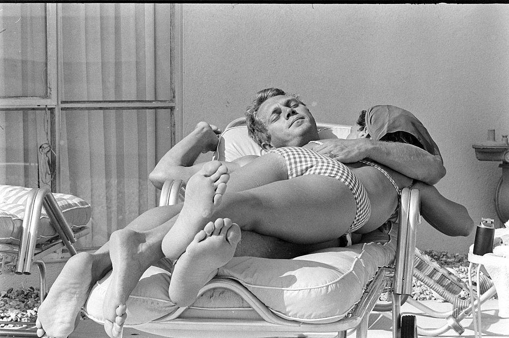 Neile Adams with her hsuband Steve McQueen, lie together on a deck chair, Hollywood, California, 1963.