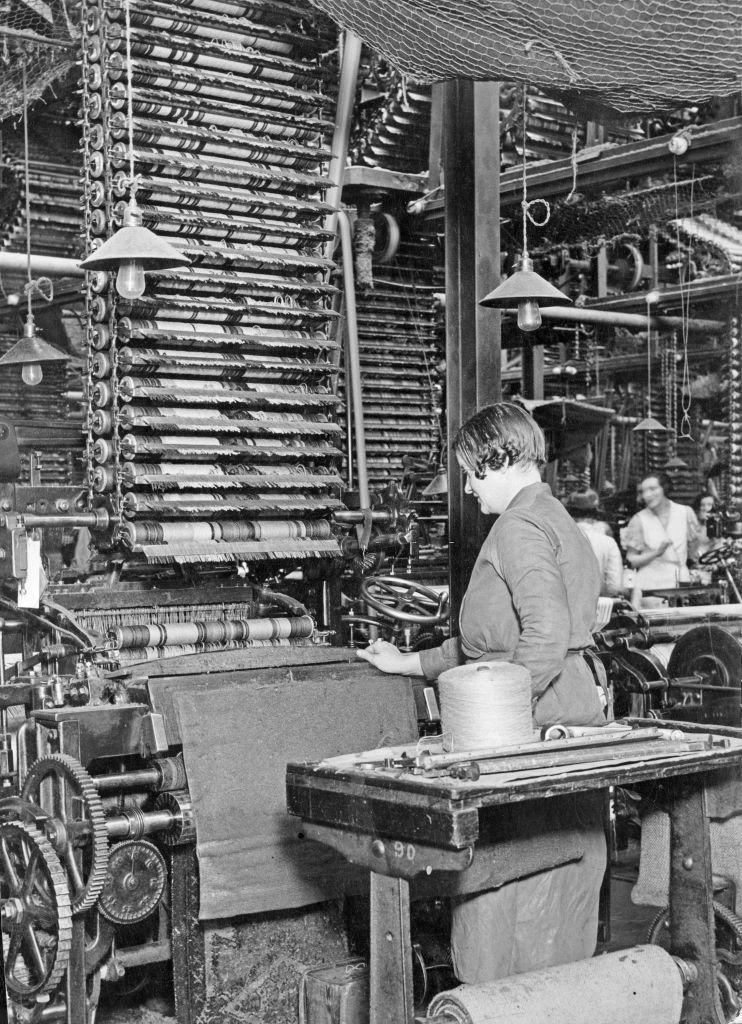 A woman worker operating one of the countless looms in the Axminster department, 18th April 1933.