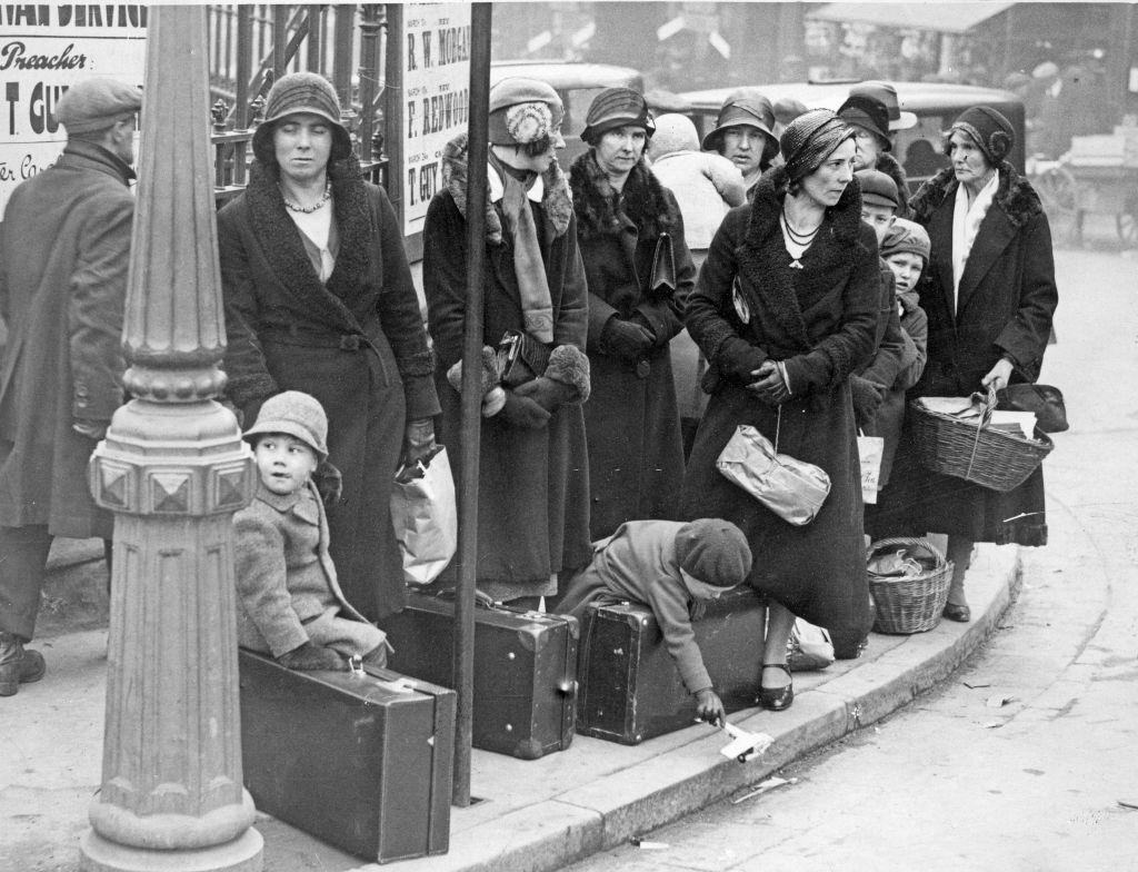 Ladies with their young charges await the bus to take them on their holidays at Easter, 27th March 1932.