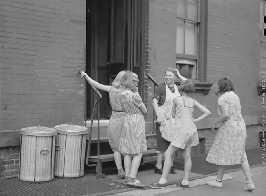 A woman and girls at the back of an apartment house on East 63rd Street
