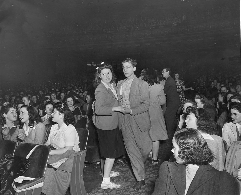 Teenage couple dancing in the aisle of New York's Paramount Theater, 1930s.