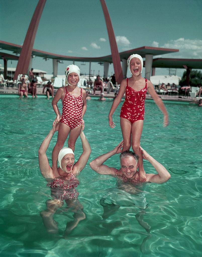 Actress Betty Hutton with her daughter, Candy (left) and hotelier Wilbur Clark with her daughter, Lindsey (right) in the pool of Clark's hotel, Las Vegas, 1956.