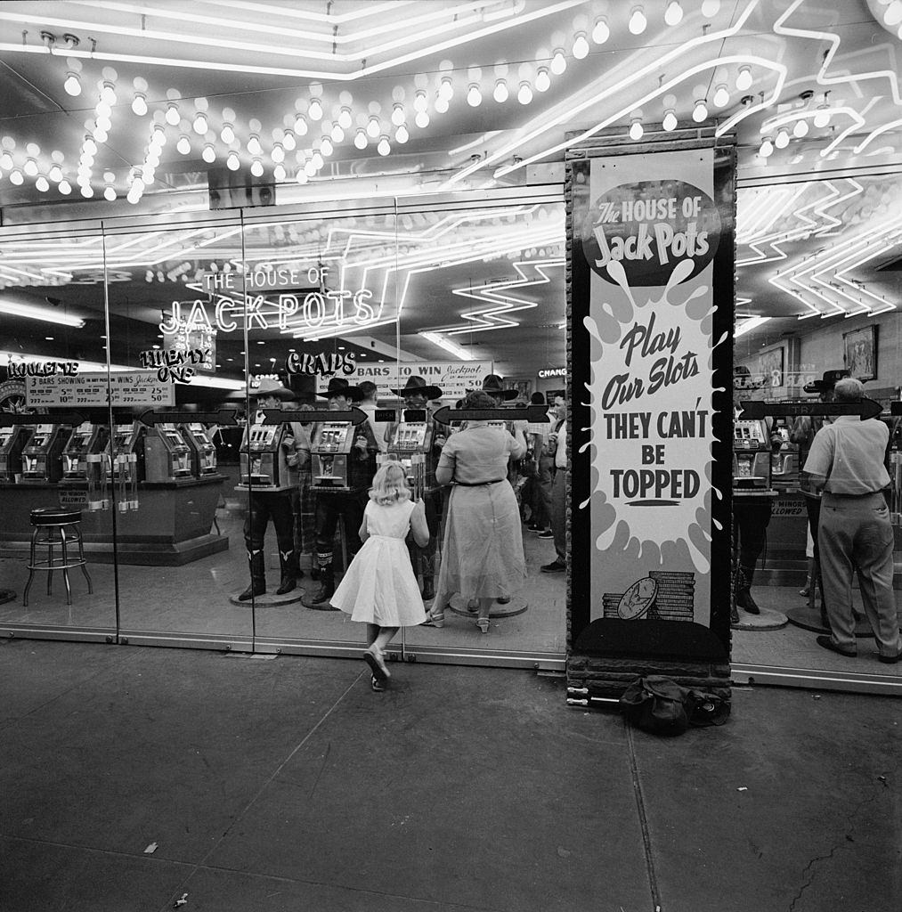 A young girl looks at patrons and slot machines through the plate-glass windows at the 'House of Jack Pots,' Las Vegas, 1955.