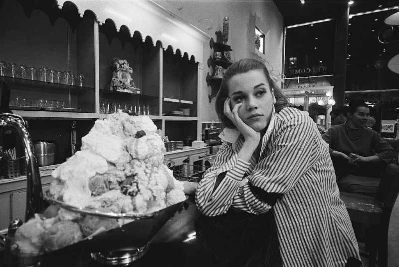 A tired Jane Fonda leaning on the counter at Hicks & Son, where she is working between her classes.