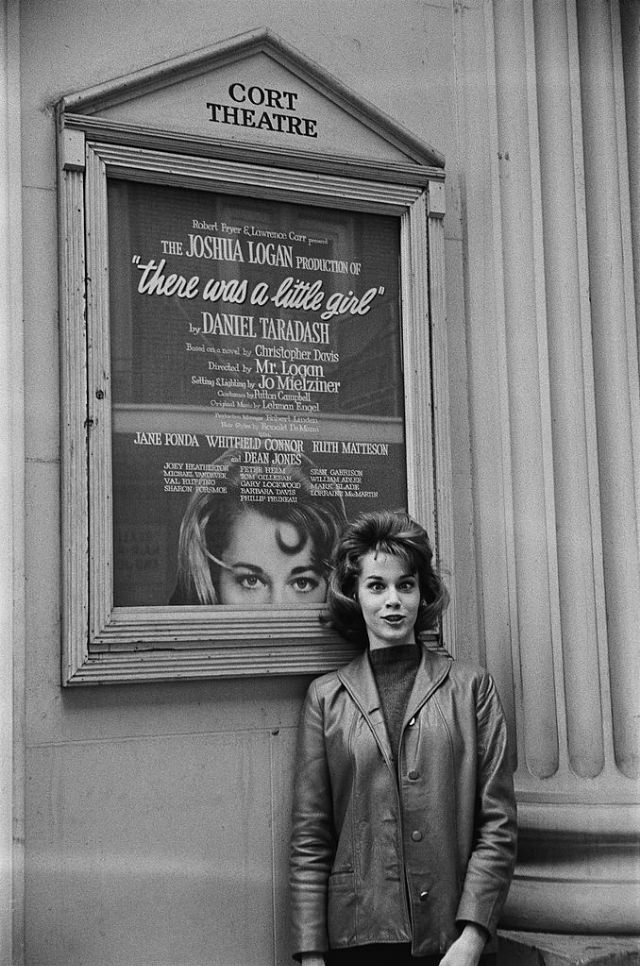 Jane Fonda posing in front of the poster of her play at the Cort Theatre.