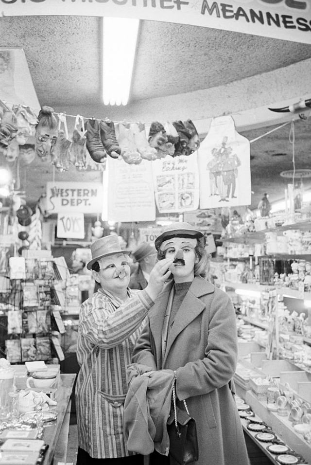Jane Fonda trying on a mask in a drugstore.