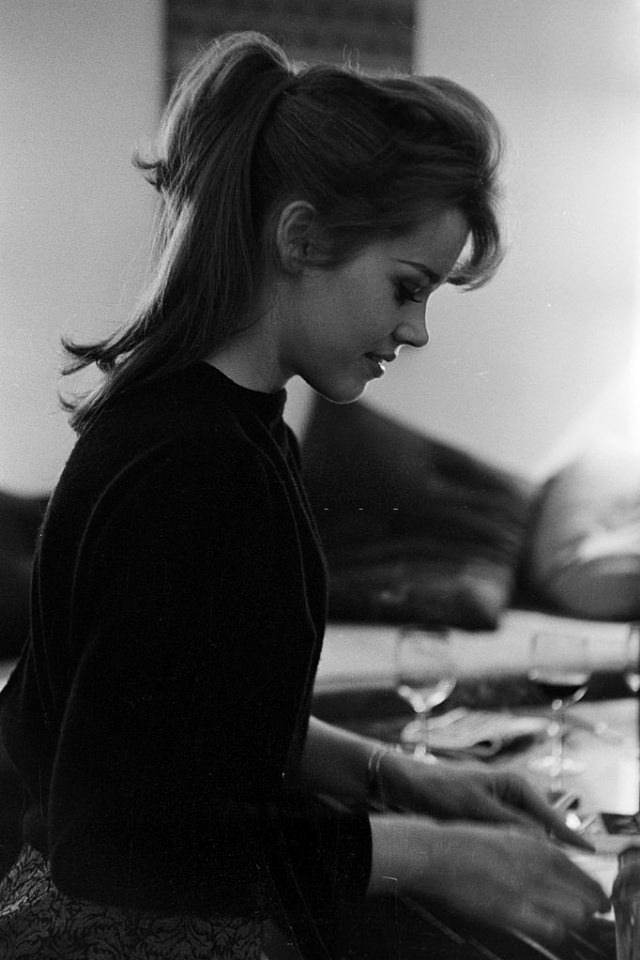 Side view of Jane Fonda sitting at the dinner table at her shared apartment.