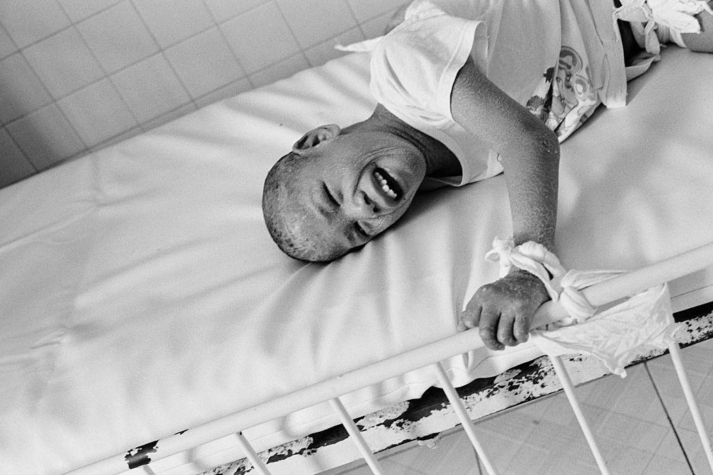 A child is tied to his cot to prevent him from injury at the Peace Village at Tu Du hospital in Ho Chi Minh City, 2005