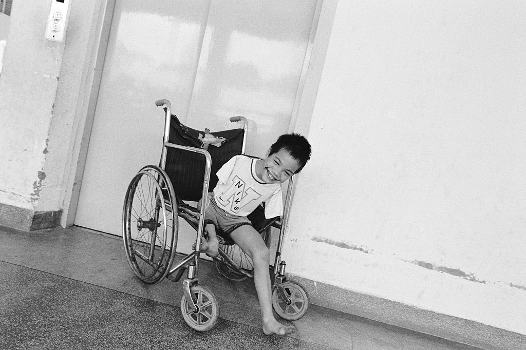 A smiling boy sits in a wheelchair at the Peace Village at Tu Du hospital in Ho Chi Minh City, 2005