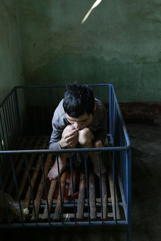 Truong Tan Thong, a 25-year-old soldier's son who has spent most of his life in a playpen. He is a victim of the Agent Orange legacy, 20 April 2005