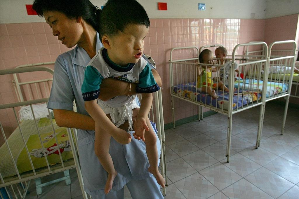 Khung Thoung Sinh, age 3, is held by a nurse at the Tu Du Hospital May 2, 2005 in Ho Chi Minh City