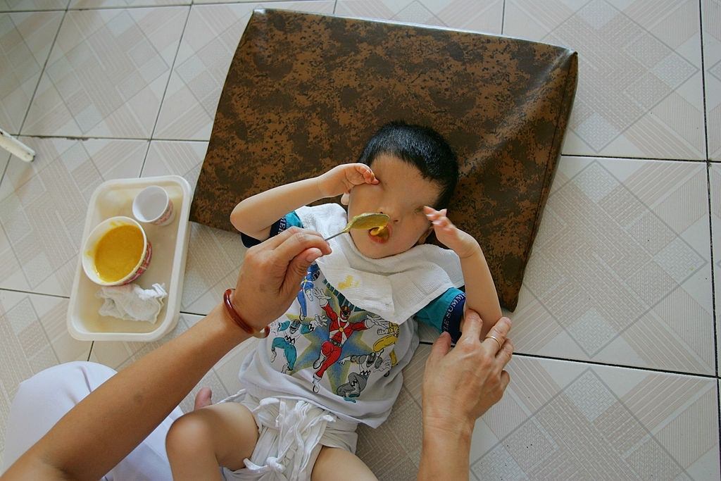 Khung Thoung Sinh, age 3, is fed by a nurse at the Tu Du Hospital May 2, 2005