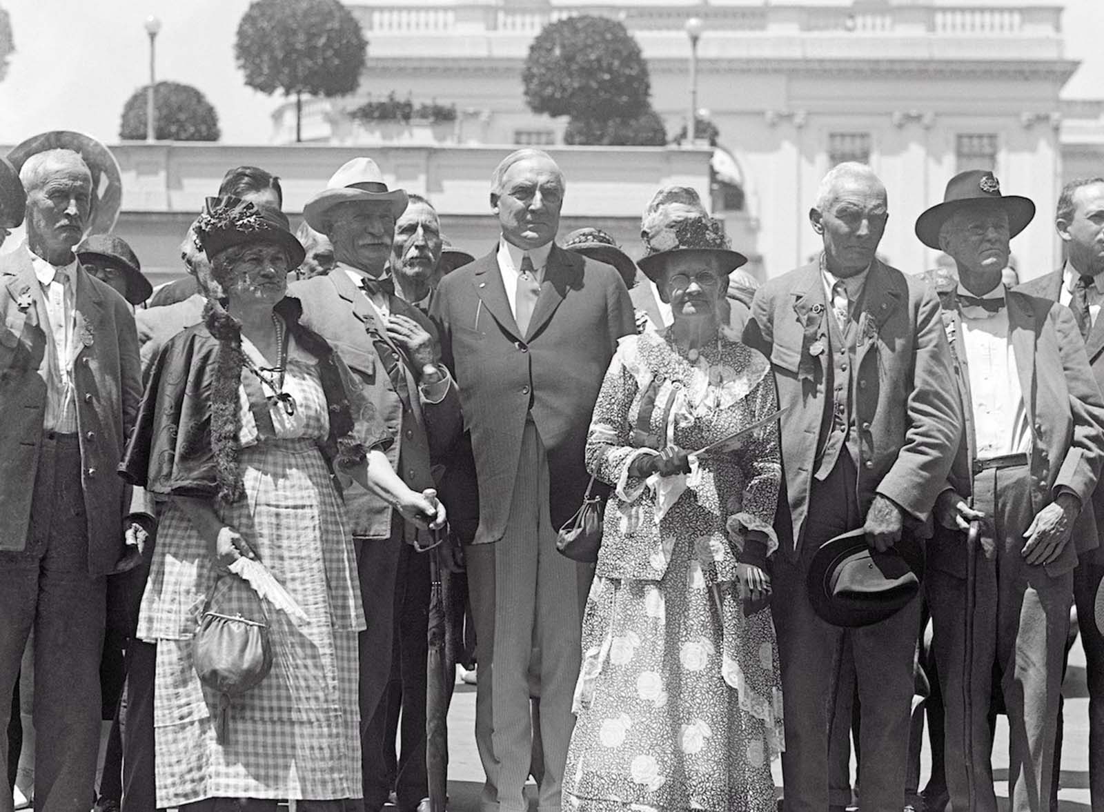 Washington, D.C. — President Harding receives veterans of the Confederate Army who have been attending their annual reunion at Richmond, Virginia. Old soldiers who fought under the Stars and Bars during the Civil War are shown here with the president, who welcomed them to the White House. 1922.