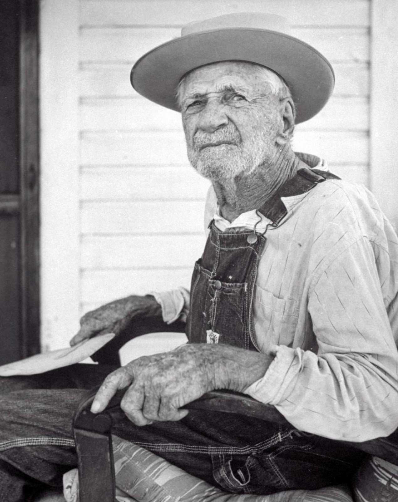 Self-proclaimed “Confederate Civil War veteran” William Lundy sitting on his porch. 1956.