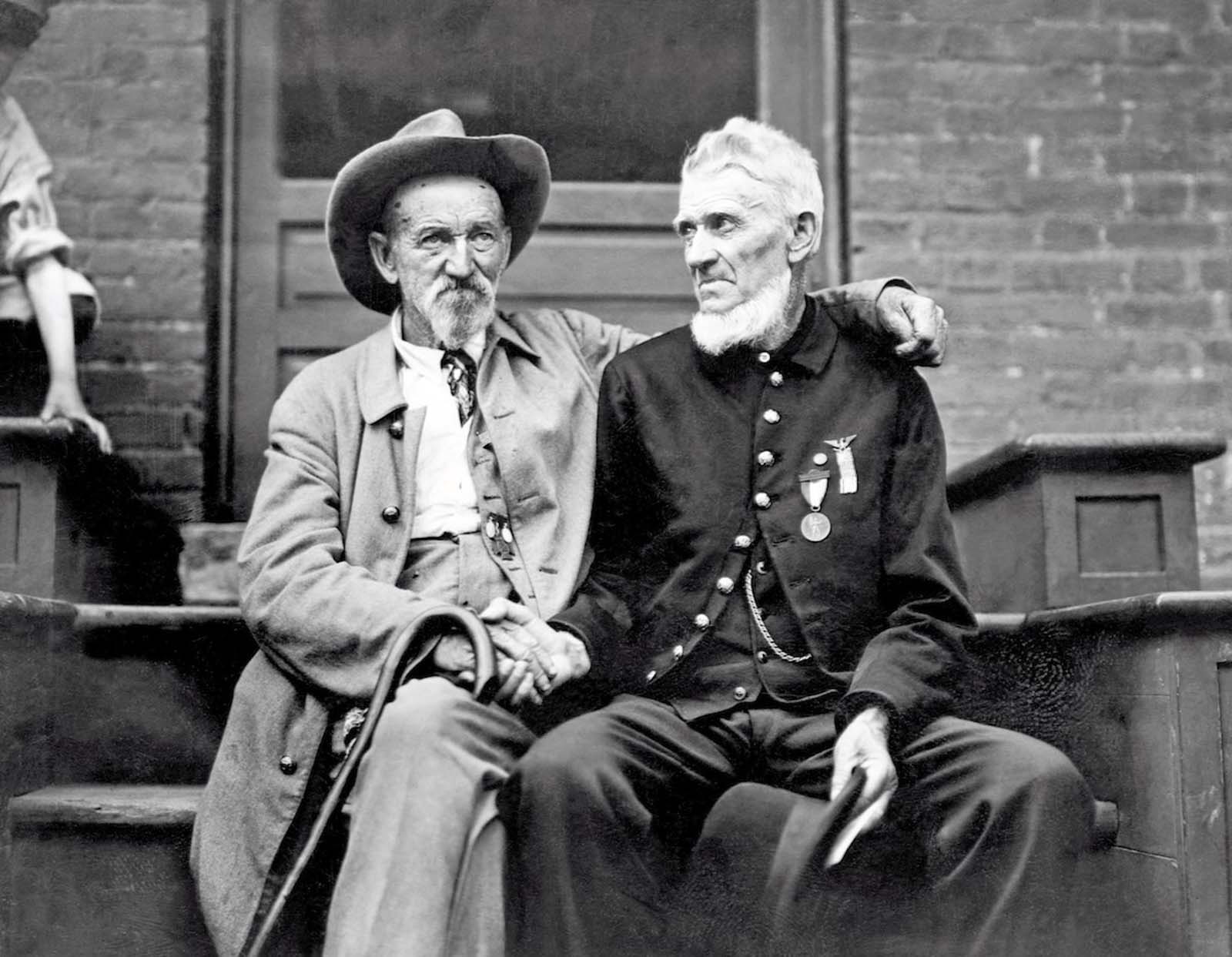 A veteran of the Union Army shakes hands with a Confederate veteran at the Gettysburg celebration, in Pennsylvania. 1913.