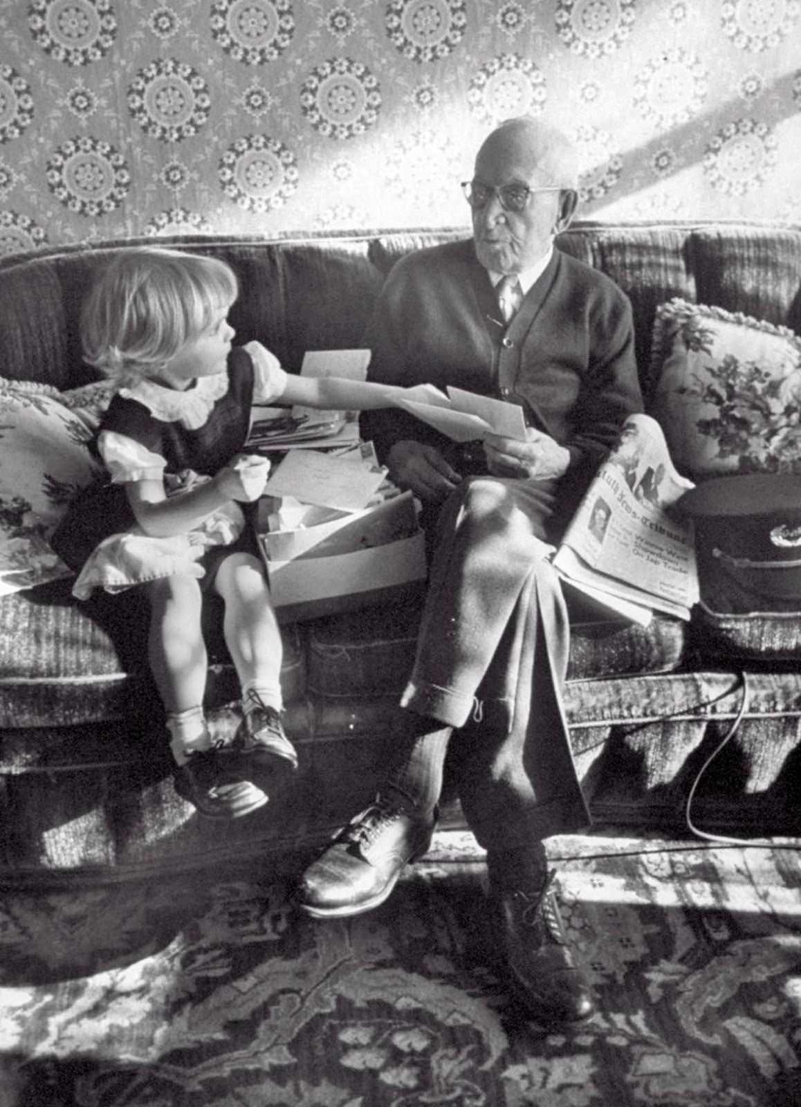 107 years old last remaining GAR Civil War Veteran Albert Woolson, relaxing on the couch while a little girl helps him sort through some mail. 1954.