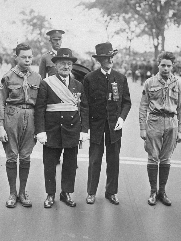 George C. Eldridge (left) and Mark S. Coxson, Civil War veterans and the grand marshal and adjutant of the Memorial Day parade, stand with boy scouts on Riverside Drive, 1930.