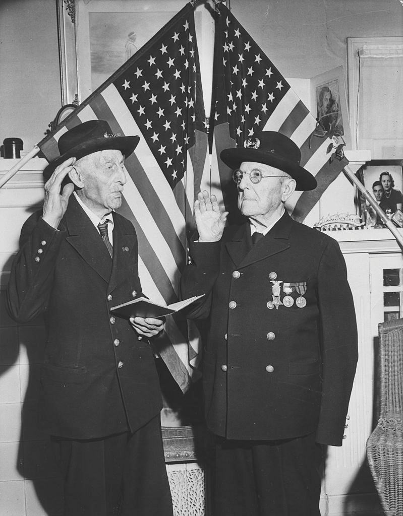 Two 99-year-old veterans of the Grand Army of the Republic (GAR) of the US Civil War standing in front the US flag, 22nd March 1946.