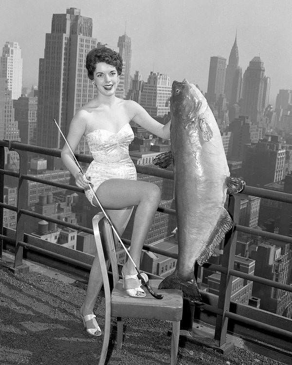 Gail Hooper, 18, from Memphis, Tennessee, selected as Miss National Catfish Queen, holds a 56-pound catfish at the Hotel New Yorker, 1954.