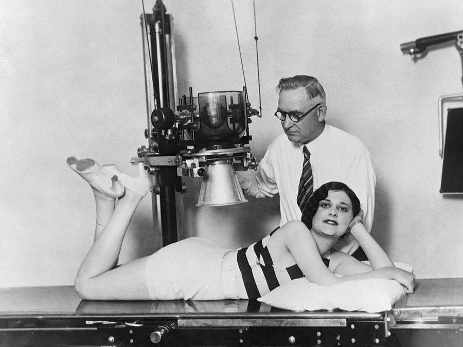 Ruth Hurschler, a contestant in a Perfect Back contest, is examined and X-rayed by a chiropractor in the final stage of the competition, Los Angeles, Circa 1930.