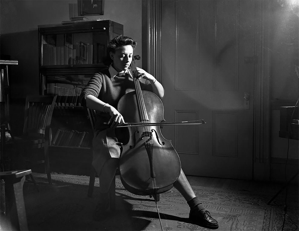 A woman, associated with the Howard University School of Music, playing a cello.