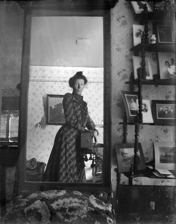 Unidentified woman taking a mirror selfie with a box camera, 1900.