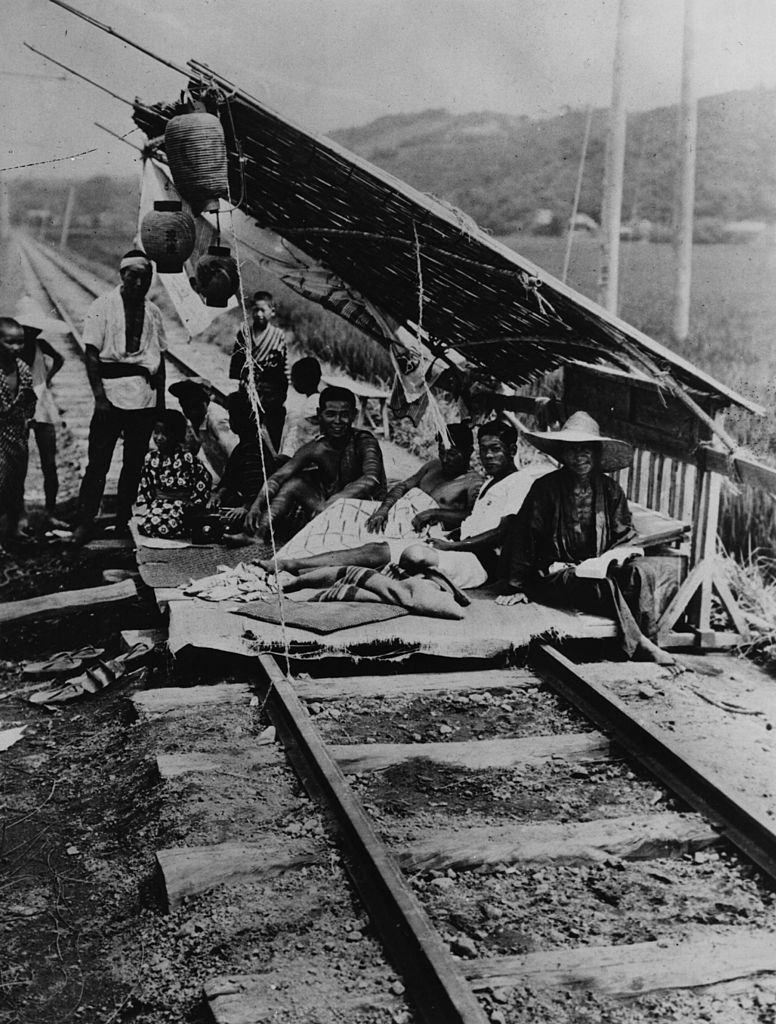 Emberek ideiglenes menedékhelyen egy vasúton a 1923. évi japán földrengés után.
