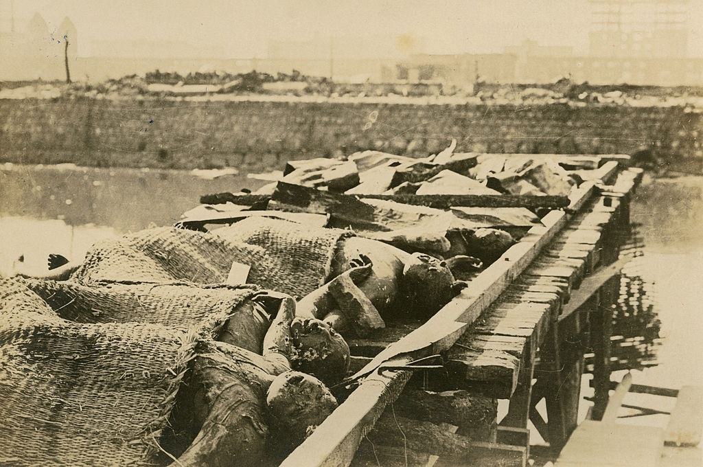 Az áldozatok testét, akik belementek a folyóba, hogy elkerülje a hatalmas tüzet, a mólóra helyezik a 1923 szeptemberi Kanto földrengés után.
