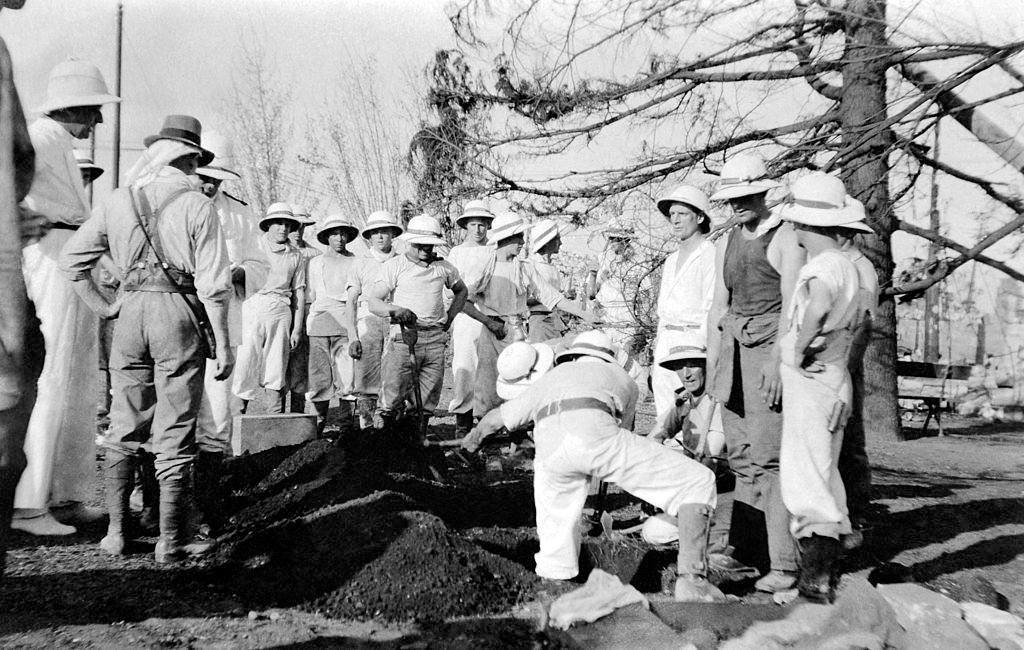 A burial during a funeral after the Tokyo earthquake in Japan, circa 1923.