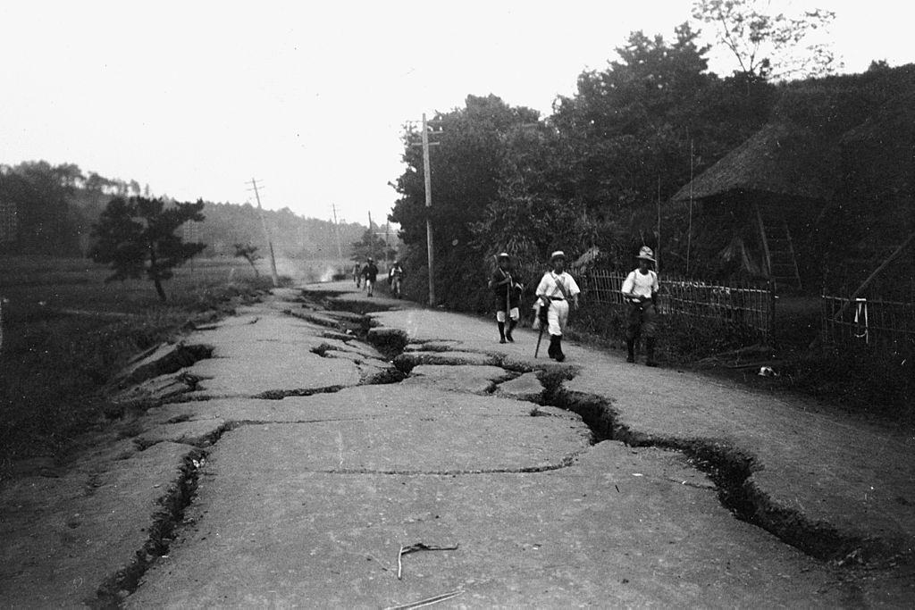 A földrengés túlélői 1923 szeptemberében sérült úton járnak a japán Kanagawa-i Totsukában.