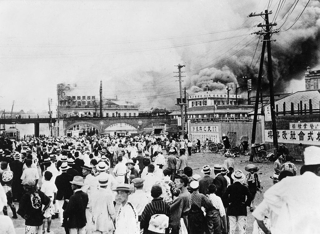 Az emberek az utcán és a házak égnek az 1923-as földrengés után.
