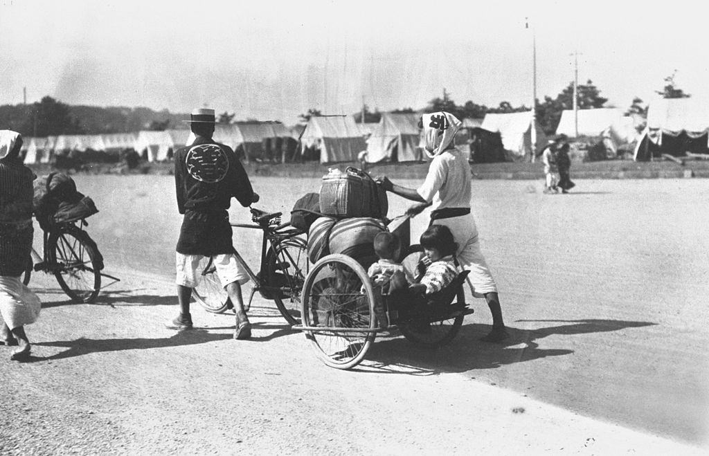 Earthquake survivors evacuated at a square in front of the Imperial Palace walk with their belongings in September 1923.